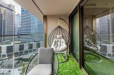 a balcony with two swinging chairs on a building at Modern 1BR Canal View Pool View in Dubai