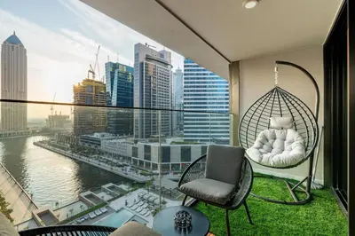 a room with a swing and a chair on a balcony at Modern 1BR Canal View Pool View in Dubai