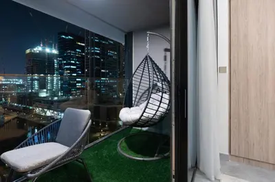 a room with a hammock on a balcony with a city skyline at Modern 1BR Canal View Pool View in Dubai