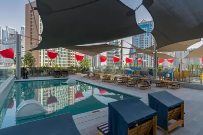 a swimming pool with tables and chairs on a building at Luxury 2BR Business Bay Balcony in Dubai