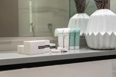 a bathroom counter with some products and a vase at Luxury 2BR Business Bay Balcony in Dubai