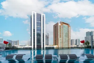 a swimming pool with chaise lounge chairs in a city at Luxury 2BR Business Bay Balcony in Dubai