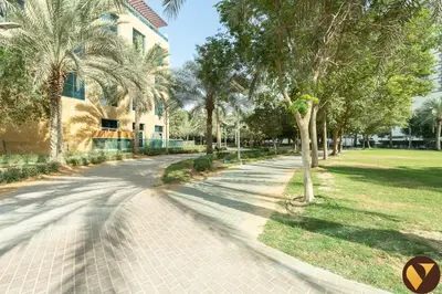 a street with palm trees and a building at Vogue JVC Jeewar Tower Near Circle Mall, One Bedroom Apartment with Balcony and City View, Access to all Amenities in Dubai