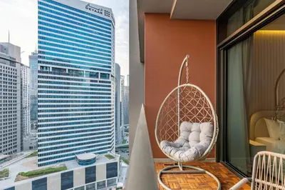 a hanging chair on a balcony with a view of a city at Modern Studio Canal & Pool View Business Bay in Dubai