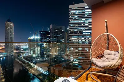 a room with a view of a city at night at Modern Studio Canal & Pool View Business Bay in Dubai