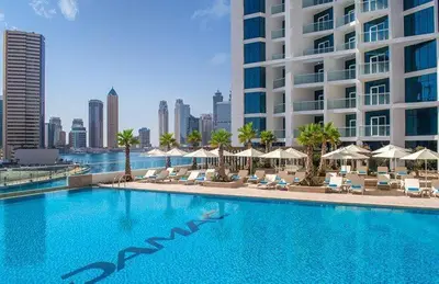 a large swimming pool with chairs and umbrellas and a building at Opulent Suites - Business Bay - Downtown in Dubai