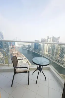 a table and a chair on a balcony with a view at Opulent Suites - Business Bay - Downtown in Dubai