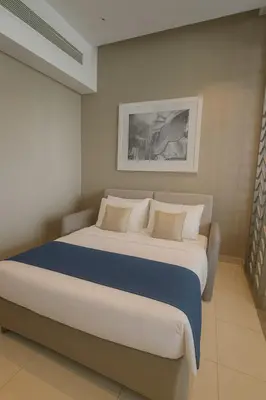 a bedroom with a large bed with blue and white pillows at Opulent Suites - Business Bay - Downtown in Dubai