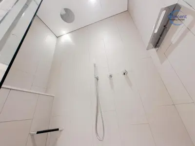 a bathroom with a shower with white tiles at Premium 1 Bedroom Stay in Berkeley Place in Dubai