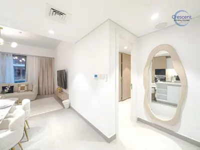 a white living room with a large round mirror at Premium 1 Bedroom Stay in Berkeley Place in Dubai