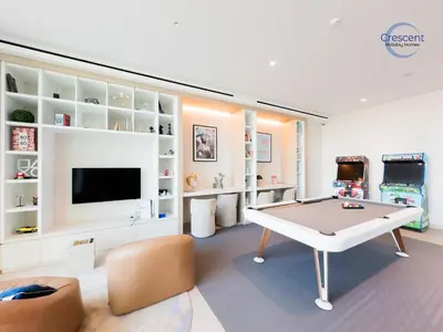a living room with a ping pong table and a tv at Premium 1 Bedroom Stay in Berkeley Place in Dubai