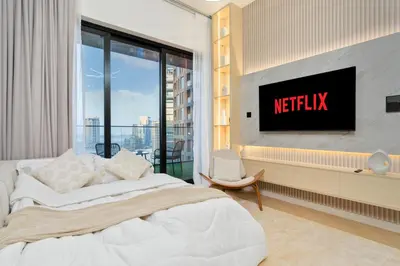 a bedroom with a bed and a tv on a wall at Stylish 1BR Canal & Burj View High Floor in Dubai