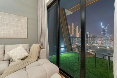 a living room with a couch and a view of a city at Stylish 1BR Canal & Burj View High Floor in Dubai