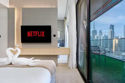 a hotel room with a bed with a tv and a window at Stylish 1BR Canal & Burj View High Floor in Dubai