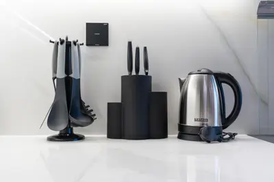 a kitchen counter with a coffee pot and utensils at Stylish 1BR Canal & Burj View High Floor in Dubai
