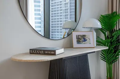 a shelf in a room with a mirror and a book at Frank Porter - Peninsula One in Dubai
