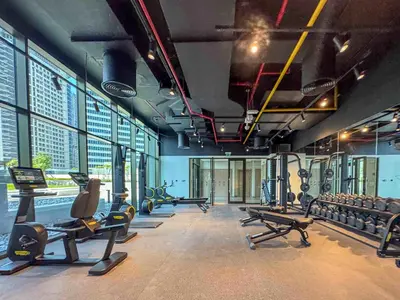 a gym with several treadmills and cardio machines at Frank Porter - Peninsula One in Dubai