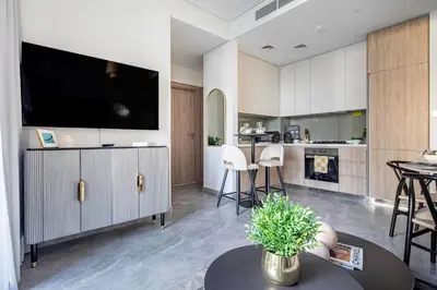 a living room with a tv and a kitchen at Frank Porter - Peninsula One in Dubai