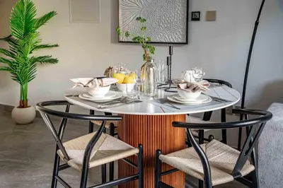 a table with two chairs and a table with plates and drinks at Frank Porter - Peninsula One in Dubai