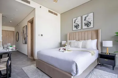 a bedroom with a large bed and a desk at Frank Porter - Peninsula One in Dubai