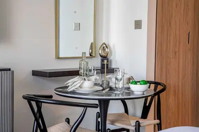 a dining room table with two chairs and a mirror at Frank Porter - Peninsula One in Dubai