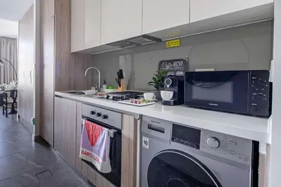 a kitchen with a washing machine and a microwave at Frank Porter - Peninsula One in Dubai