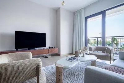 a living room with a flat screen tv and a large window at Frank Porter - La Voile in Dubai