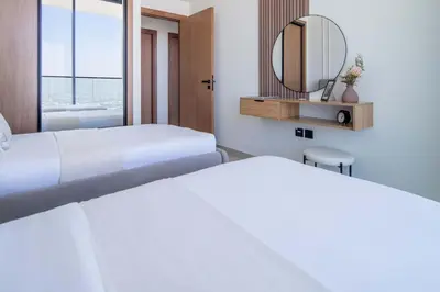 a hotel room with two beds and a mirror at Frank Porter - Binghatti Onyx in Dubai