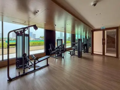 a gym with cardio equipment in a building with a large window at Frank Porter - Binghatti Onyx in Dubai