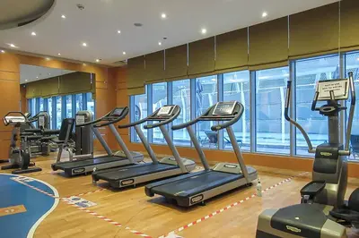 a gym with several treadmills in a row at Frank Porter - The Signature in Dubai