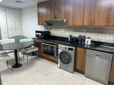 a kitchen with a washing machine and a table at Sea View Luxe Room Marina Dubai in Dubai