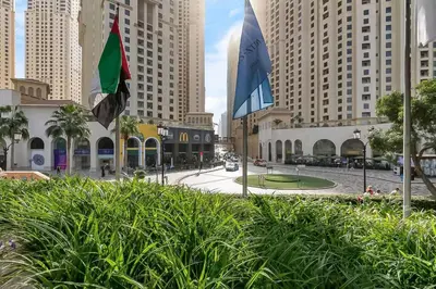 two flags are flying in a city with tall buildings at Sadaf 2701 in Dubai