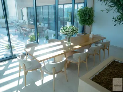 a wooden table and chairs in a room with windows at Elegant Haven by Meraki - New 1 Bed Garden View in Dubai