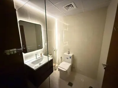 a bathroom with a sink and a toilet and a mirror at Aesthetic Feel with Lake View in Dubai