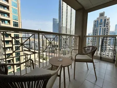 a balcony with a table and chairs and a view of a city at Luxurious 1Bedroom Apt in 29 Boulevard - Downtown in Dubai