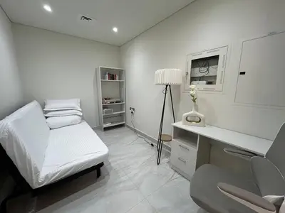 a white room with a bed and a desk at Luxury two bedroom at Gemz in Dubai