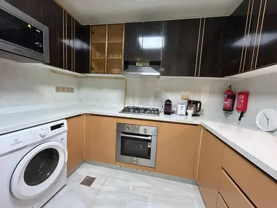 a kitchen with a washing machine and a washer at Luxury two bedroom at Gemz in Dubai