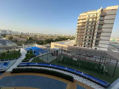 a building with a tennis court in front of a building at Luxury two bedroom at Gemz in Dubai