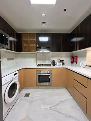 a kitchen with a stove and a washer and dryer at Luxury two bedroom at Gemz in Dubai