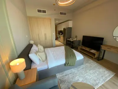 a bedroom with a bed and a flat screen tv at Bright and Stylish Studio - Azizi Aura in Dubai