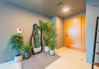 a hallway with potted plants in front of a mirror at Stylish Two-BHK Apartment - Iris Blue, Marsa Dubai in Dubai
