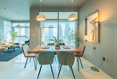a dining room with a table and chairs at Stylish Two-BHK Apartment - Iris Blue, Marsa Dubai in Dubai