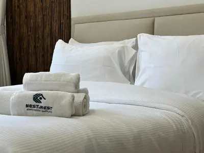 a bed with white sheets and towels on it at Comfortable one bed - Gym and Parking in Dubai
