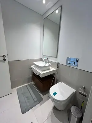 a bathroom with a toilet and a sink and a mirror at Comfortable one bed - Gym and Parking in Dubai