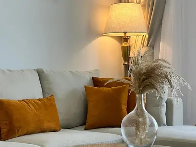 a vase sitting on a table next to a couch at Comfortable one bed - Gym and Parking in Dubai