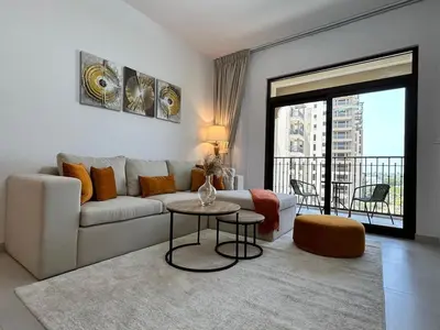 a living room with a couch and a table at Comfortable one bed - Gym and Parking in Dubai