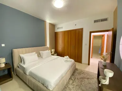 a bedroom with a large white bed in a room at Modern 2BR in Skycourt Tower A - Free Parking - Pool and Gym in Dubai