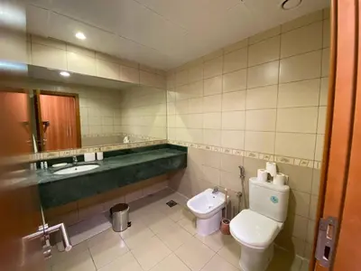 a bathroom with a toilet and a tub and a sink at Modern 2BR in Skycourt Tower A - Free Parking - Pool and Gym in Dubai