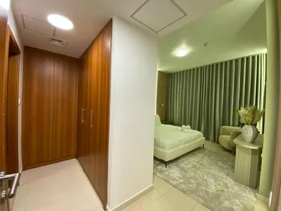 a room with a bedroom with a bed and a couch at Modern 2BR in Skycourt Tower A - Free Parking - Pool and Gym in Dubai