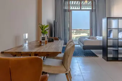 a living room with a dining table and a bedroom at Stylish Studio Apt in Palm Views East PalmJumeirah in Dubai